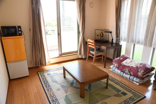 a living room with a coffee table and a desk at ファミリー不向き!!素泊まり一棟貸切りではない個室の静かな方限定無料WiFi in Irumagawa