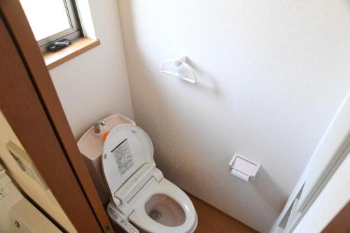 a small bathroom with a toilet and a window at ファミリー不向き!!素泊まり一棟貸切りではない個室の静かな方限定無料WiFi in Irumagawa