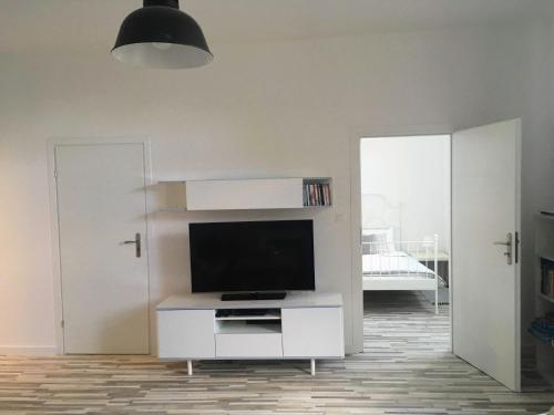 a living room with a flat screen tv on a white cabinet at Domek na wsi Mokosz in Kwilcz