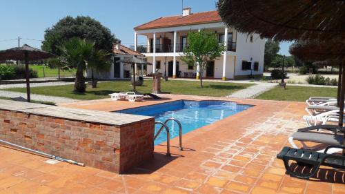 a swimming pool in front of a house at Quinta da Abrunheira in Vimieiro