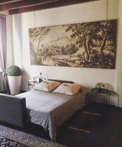 a bedroom with a bed with a painting on the wall at Le Kraken Charme & Relax in Bergamo