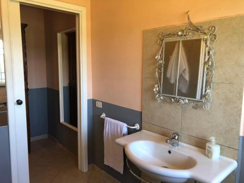 a bathroom with a sink and a mirror on the wall at La Locanda della Vecchia Hosteria in Gavorrano