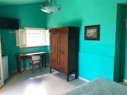 a room with a desk and a cabinet and a table at La Locanda della Vecchia Hosteria in Gavorrano