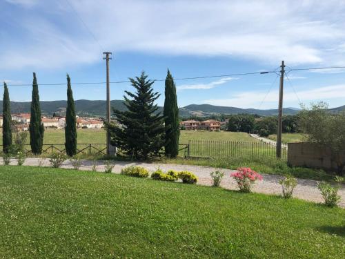 a garden with trees and flowers and a fence at La Locanda della Vecchia Hosteria in Gavorrano
