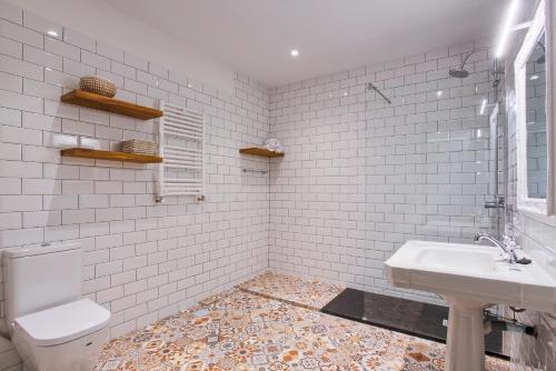 a white bathroom with a sink and a toilet at Serrano Comfort, by Presidence Rentals in Madrid