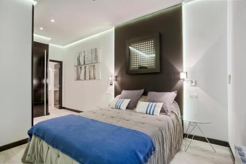 a bedroom with a large bed with a blue blanket at Serrano Comfort, by Presidence Rentals in Madrid