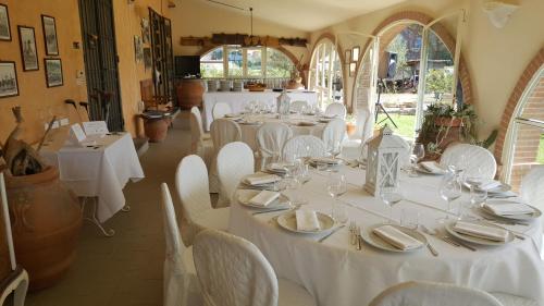 La Locanda della Vecchia Hosteria في غافورانا: غرفة طعام مع طاولات بيضاء وكراسي بيضاء