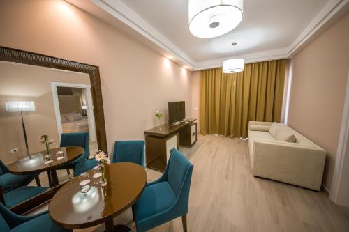 a hotel room with a table and chairs and a couch at Sole Luna Hotel in Borsh