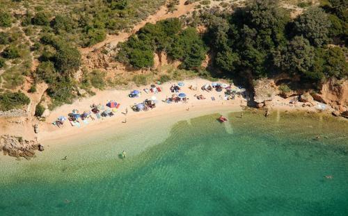 an aerial view of a beach with people and umbrellas at Apartments Banic in Rab