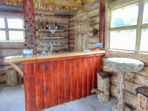 eine Bar in einer Blockhütte mit einem Tisch in der Unterkunft Cottage Uskoci in Žabljak