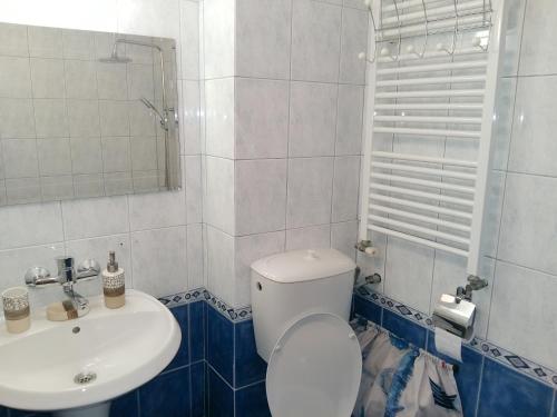 a bathroom with a white toilet and a sink at Fresh Apartment in Sofia