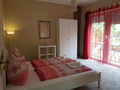 a bedroom with a bed and a large window at Doris Apartments in Siófok
