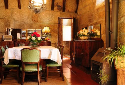 a dining room with a table with chairs and a chandelier at Casa do Fundo - Sustainable & Ecotourism in Seia