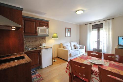 Il comprend une cuisine et un salon avec une table. dans l'établissement Apartamentos San Jorge, à Nueva de Llanes