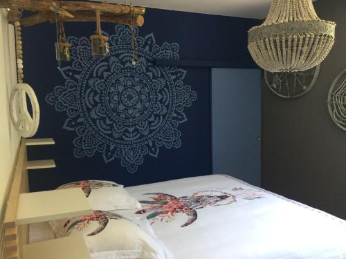 a bedroom with a blue wall with a mandala mural at L'Xpérience in Valgorge