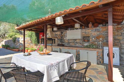 a table and chairs on a patio with a kitchen at Niki Apartments in Panormos Skopelos