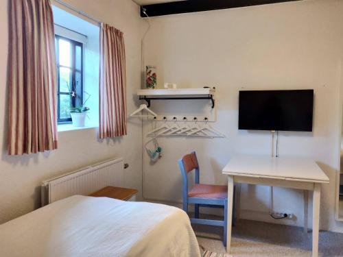 1 dormitorio con 1 cama, escritorio y TV en Dåstrup Bed & Breakfast, en Viby