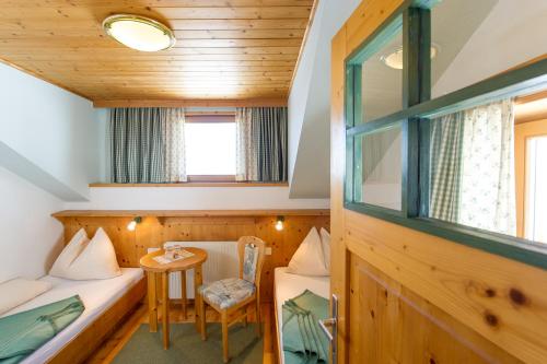 a small room with two beds and a table at Sattleggers Alpenhof & Feriensternwarte in Berg im Drautal