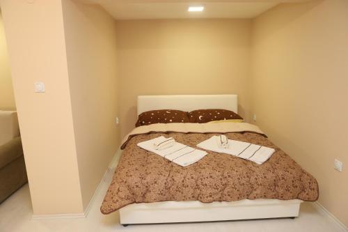 a bedroom with a bed with two towels on it at Apartman Centar 2 in Subotica