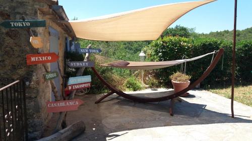 a hammock sitting on a patio with street signs at Bastide Provençale Les Mûriers d'Engaspaty in Seillans