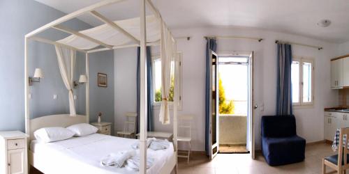 a bedroom with a white canopy bed and a bathroom at Dream Island Hotel in Livadia