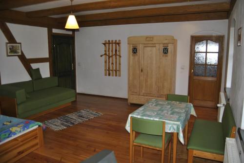 a living room with a table and chairs and a door at Jaworowa Zagroda in Domaszków