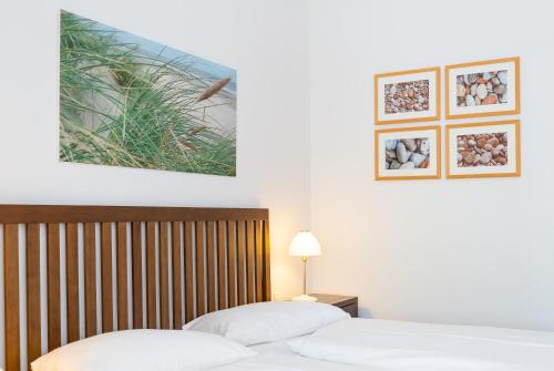 2 Betten in einem Hotelzimmer mit weißer Bettwäsche in der Unterkunft strandnahe und moderne FeWo mit Terrasse, Villa Ravensberg, Binz in Binz