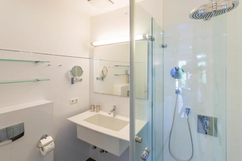 a white bathroom with a sink and a shower at Villa Ravensberg in Binz