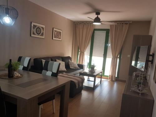 a living room with a couch and a table at Playa Muchavista lovely ground floor apartment in El Campello