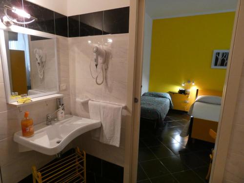 a bathroom with a sink and a phone on the wall at Affittacamere Sardegna Sole e Mare in Alghero