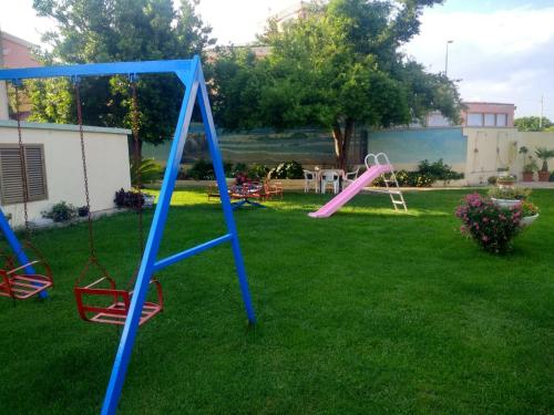 un cortile con parco giochi e scivolo rosa di Casa Vacanze Arba Girasole a Girasole