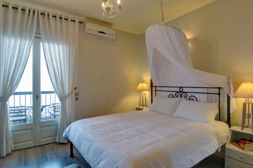 a hotel room with a white bed and a white comforter at Agapitos Villas & Guesthouses in Agios Ioannis Pelio