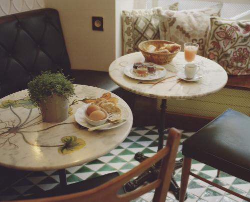 deux tables avec des assiettes de nourriture et de boissons dessus dans l'établissement Hôtel du Temps Paris, à Paris
