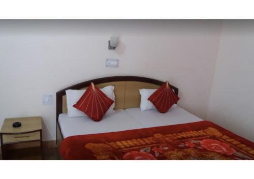 UttarkāshiにあるSahaj Villaのベッドルーム1室(赤と白の枕が備わるベッド1台付)