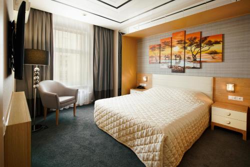 a hotel room with a bed and a chair at Berlin Hotel in Moscow