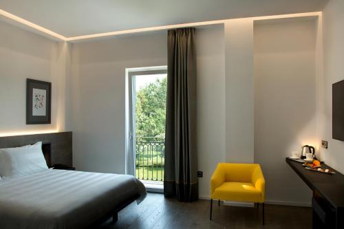 a bedroom with a bed and a yellow chair at Il San Cristoforo in Ercolano