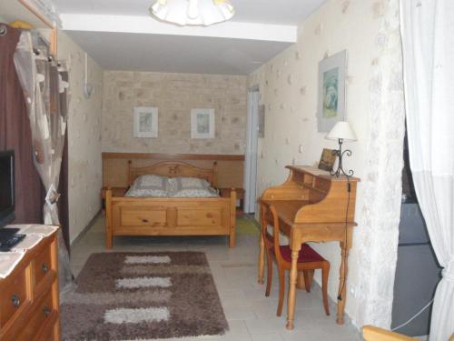 - une chambre avec un lit, un bureau et un piano dans l'établissement Domaine de Poudos, à Auterive