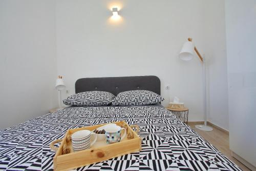 Apartment Mia في بيبينيا: سرير مع صينية عليها صحون وصحون