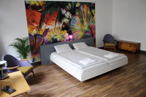 1 dormitorio con 1 cama y una pintura en la pared en Pension Wienderland, en Viena