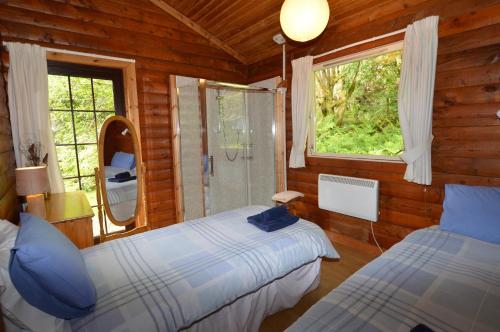 a bedroom with two beds and a window at 18 Lamont Lodges in Dunoon