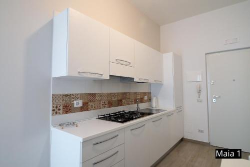 a white kitchen with white cabinets and a stove at Case Vacanze Maia in Matera