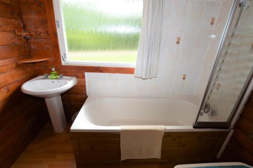 a bathroom with a bath tub and a sink at 18 Lamont Lodges in Dunoon