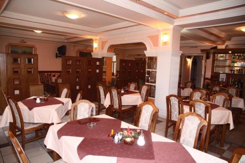 a restaurant with tables and chairs in a room at Garni Hotel PBG in Subotica