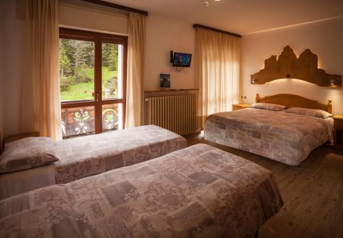 Un pat sau paturi într-o cameră la Hotel Dolomiti Des Alpes