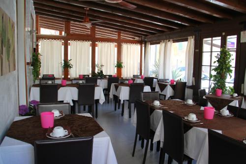 a dining room with tables and chairs with pink accents at Albergo Al Pescatore in Brenzone sul Garda