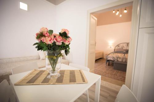 a vase of pink flowers sitting on a table at Sciabika Home - Edificio Eolie in Castellammare del Golfo