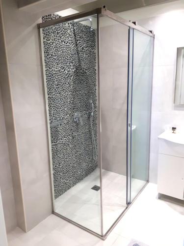 a shower with a glass door in a bathroom at Zephyros Hotel in Kamari