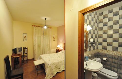 a bedroom with a bed and a bathroom with a sink at Hotel Rural Aguallevada in Paramio