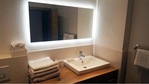 y baño con lavabo, espejo y toallas. en Appartement De Martin, en Aurach bei Kitzbuhel