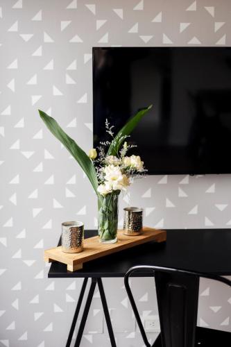 a vase of flowers sitting on a wooden table at Top Rentals WOW Nuñez in Buenos Aires